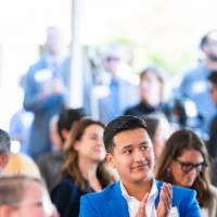 Photo of event attendees sitting in audience and clapping
